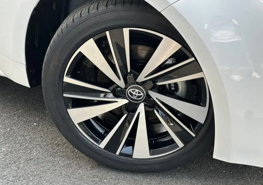 Gros plan sur la jante alliage 17'' diamantée grise et noire de la Toyota Corolla Touring Sport blanc neige, côté avant droit.