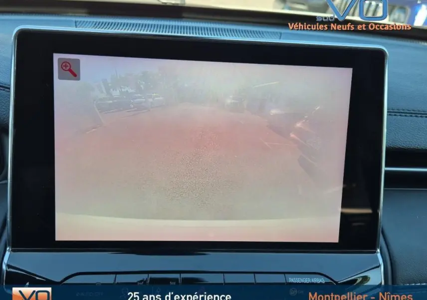 Écran tactile intérieur du Jeep Compass 2023 affichant la caméra de recul avec vue arrière floutée.