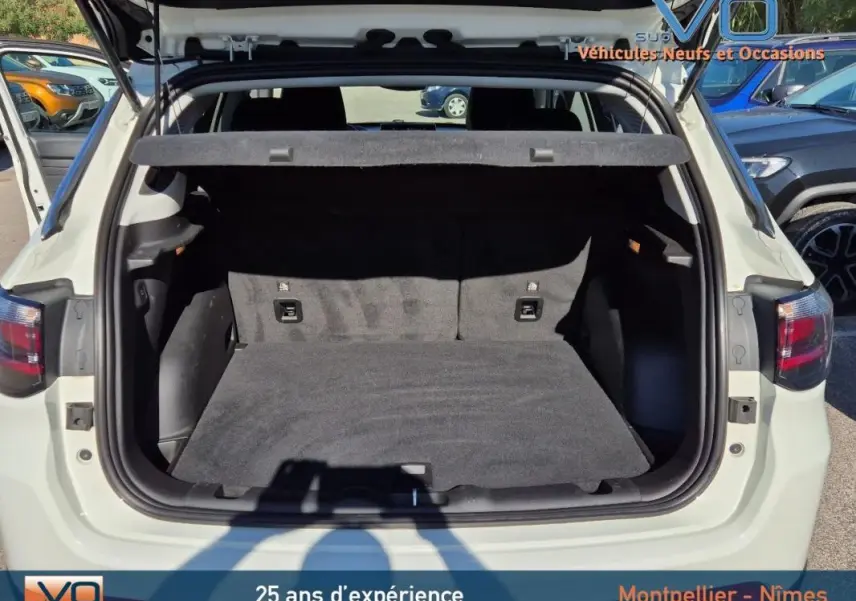 Coffre ouvert vu de l'arrière d'un Jeep Compass blanc 2023, montrant l'espace de chargement vide et la plage arrière.