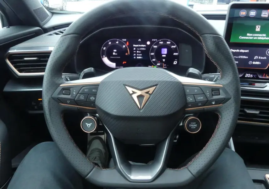 Vue rapprochée du volant perforé noir avec logo CUPRA cuivré et tableau de bord digital du Formentor 2025.