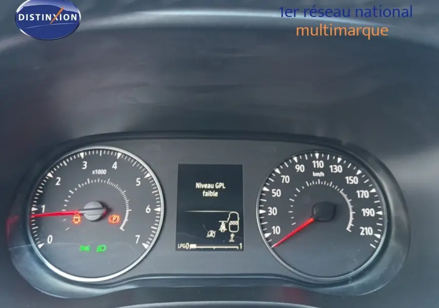 Gros plan sur le tableau de bord de la Dacia Sandero Stepway rouge, affichant un message d'alerte niveau GPL faible.