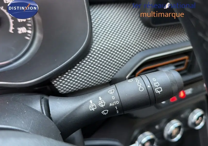 Gros plan sur la commande des essuie-glaces dans l’habitacle d’une Dacia Sandero Stepway 2021 rouge fusion.