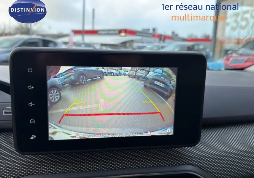 Écran de caméra de recul affichant l’arrière d’une Dacia Sandero Stepway rouge fusion en stationnement.