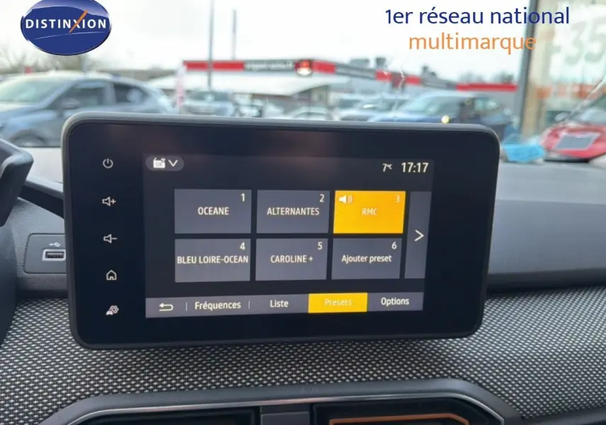 Vue avant intérieure centrée sur l’écran tactile du tableau de bord de la Dacia Sandero Stepway rouge fusion.