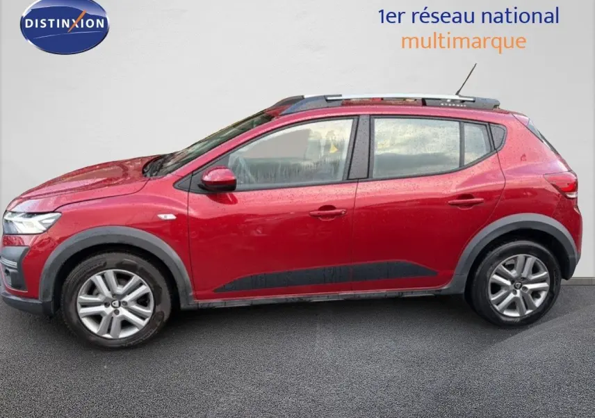 Vue de profil côté gauche d'une Dacia Sandero Stepway rouge fusion 2021 avec protections noires et jantes alliage.