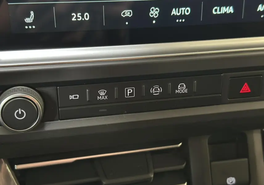 Gros plan sur la console centrale du Volkswagen Transporter T7 noir, montrant les commandes de climatisation et d’aide à la conduite.