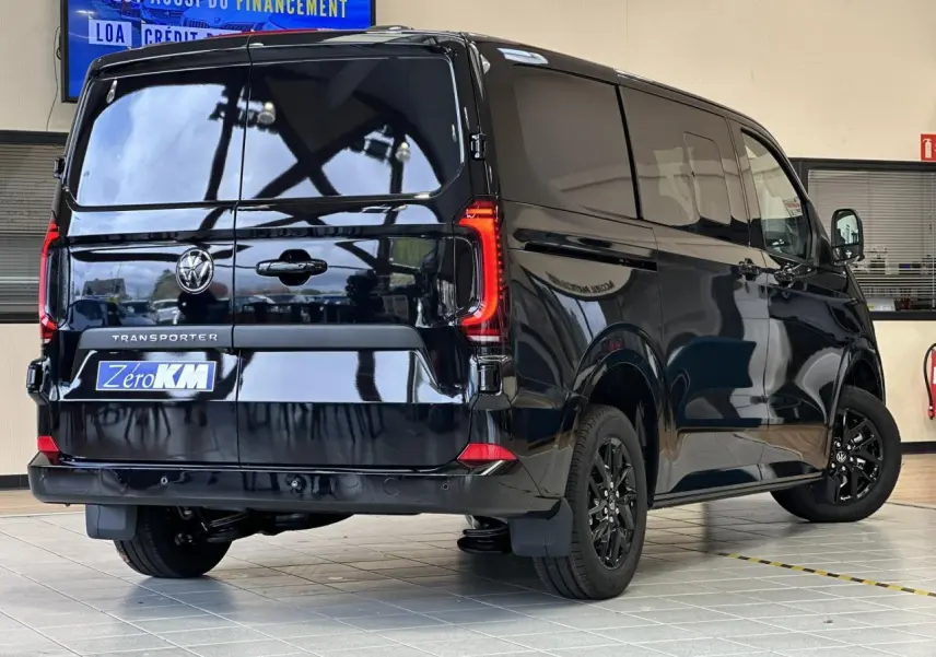 Vue 3/4 arrière droite du Volkswagen Transporter T7 ProCab noir minuit avec feux arrière LED et jantes alliage noires.
