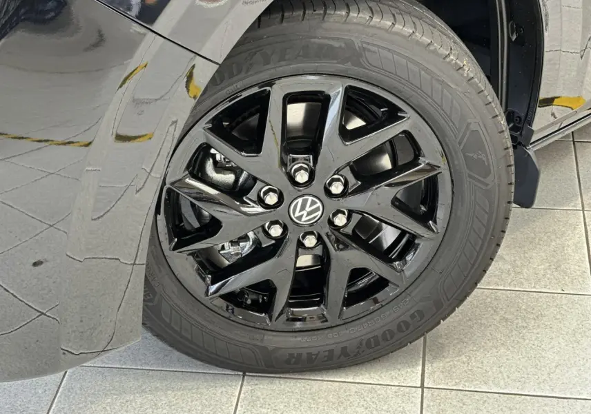 Gros plan sur la jante alliage noir brillant Le Mans 17 pouces du côté avant gauche du Volkswagen Transporter T7 noir Minuit.