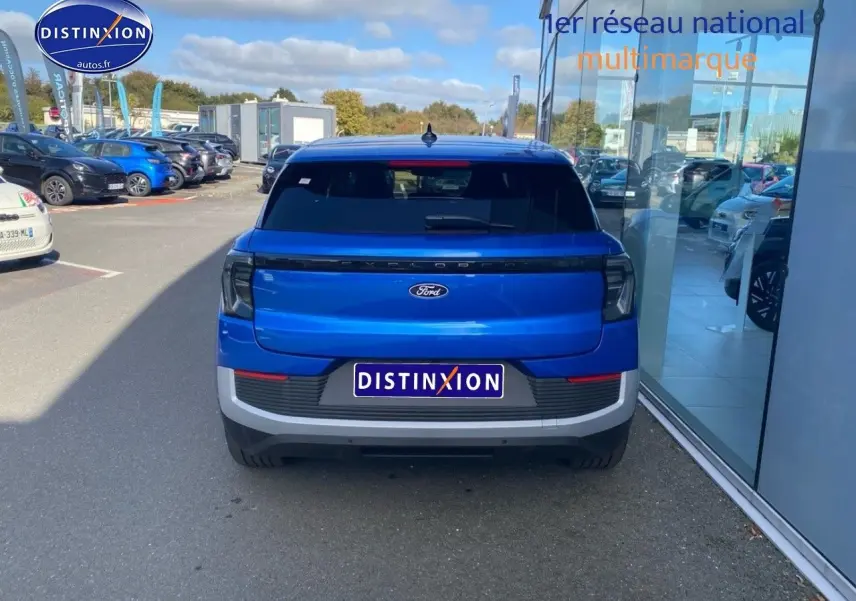 Vue arrière du Ford Explorer électrique 2025 en bleu Premium My Mind métallisé, avec feux arrière LED et lunette arrière surteintée.