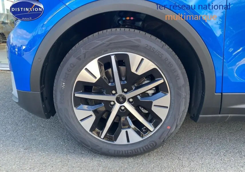 Gros plan sur la roue avant gauche du Ford Explorer 2025 en bleu métallisé avec jante alliage bicolore.