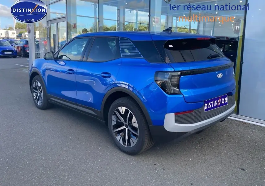 Vue 3/4 arrière droite du Ford Explorer électrique 2025 en bleu métallisé Premium My Mind, avec feux arrière LED et jantes stylées.