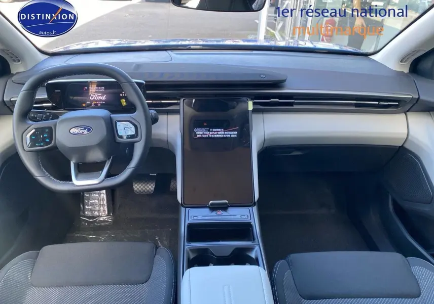 Vue intérieure avant du Ford Explorer 2025 avec tableau de bord moderne et écran tactile central vertical.