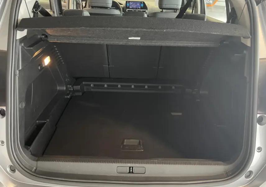 Coffre ouvert vu de l'arrière d'un Citroën C5 Aircross gris Artense 2023, avec banquette arrière et tablette tactile visibles.