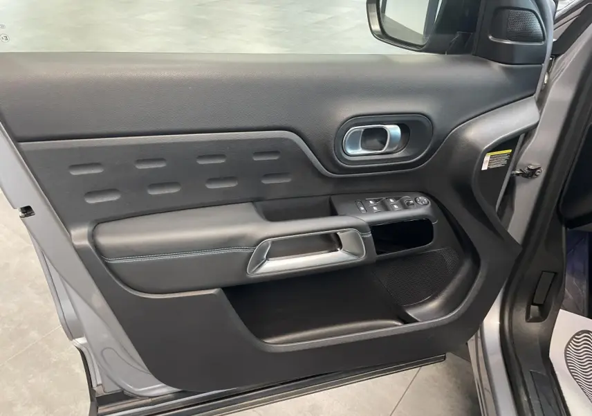Vue rapprochée de la porte avant gauche gris Artense du Citroën C5 Aircross 2023 avec garniture noire et poignée métal.