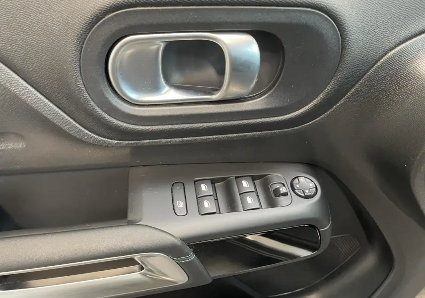 Gros plan sur la poignée intérieure et les commandes de vitres du côté gauche d’un Citroën C5 Aircross 2023 gris Artense.