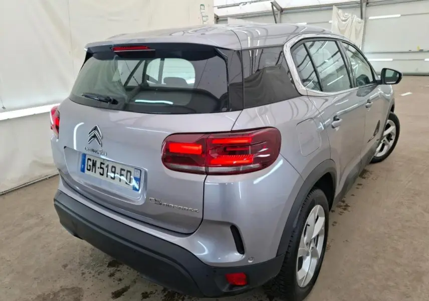 Vue 3/4 arrière droite d'un Citroën C5 Aircross gris Artense avec toit noir brillant et feux arrière LED.