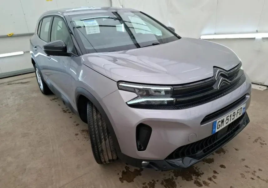 Vue 3/4 avant gauche du Citroën C5 Aircross gris Artense avec calandre noir brillant et feux LED distinctifs.