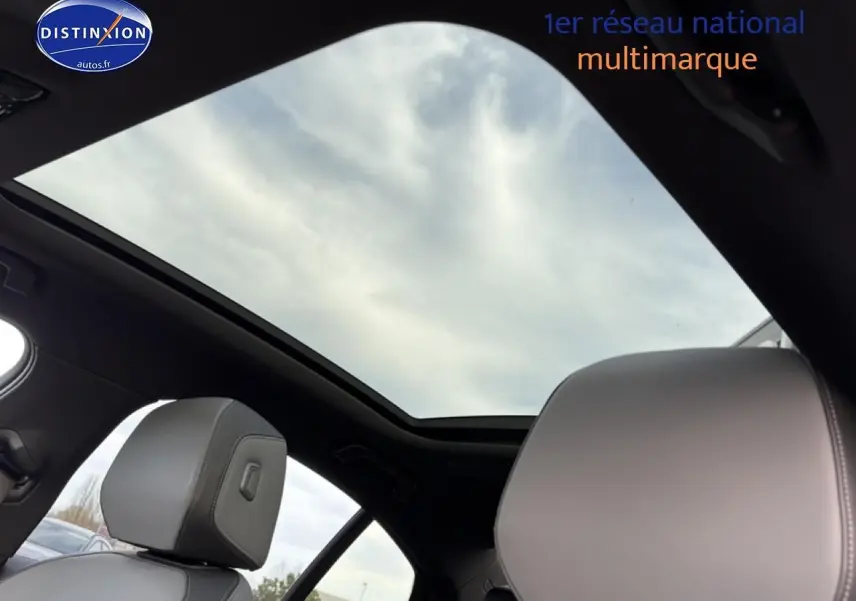 Toit panoramique et sièges avant en cuir gris clair dans une BMW Série 5 i5 M60 noire vue de l'intérieur arrière.