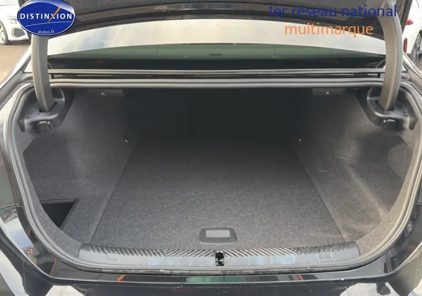 Coffre ouvert de BMW Série 5 i5 M60 noir, vue arrière montrant l'espace de rangement vide.