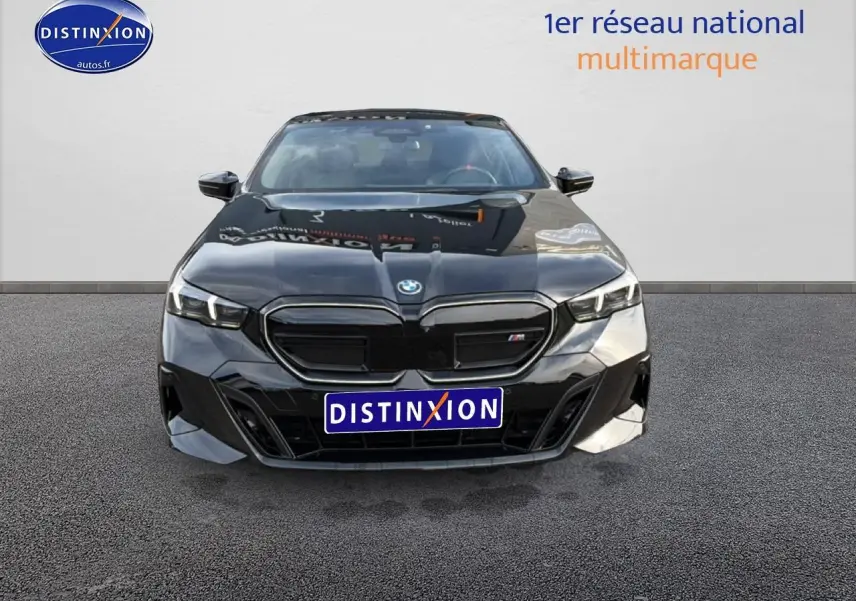 Vue avant d'une BMW Série 5 i5 M60 noire 2024 avec calandre noire et phares LED allumés.