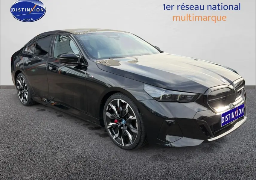 BMW Série 5 i5 M60 noire vue en 3/4 avant droit avec jantes alu bicolores et calandre marquée M.