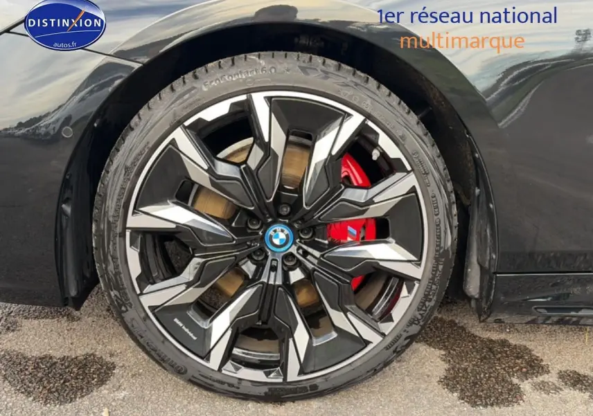 Gros plan sur la roue avant droite noire d'une BMW Série 5 i5 M60 2024 avec étrier de frein rouge visible.