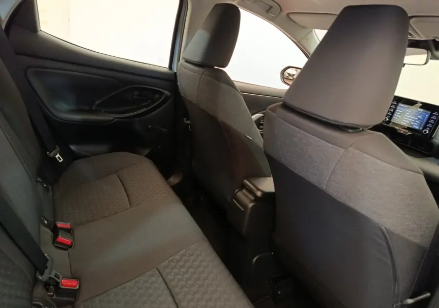 Vue intérieure arrière côté gauche de la Toyota Yaris hybride 2022, sièges tissu gris foncé avec motifs géométriques.
