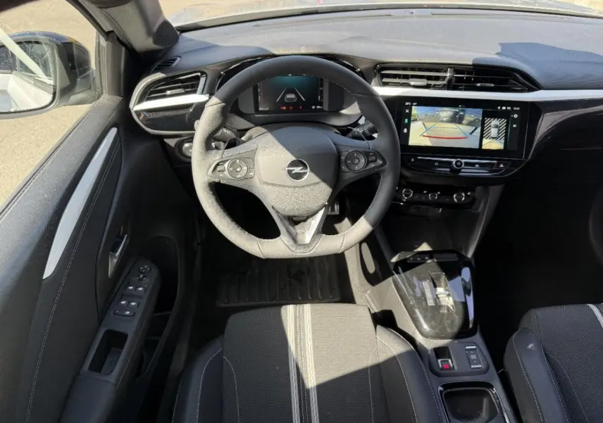 Intérieur Opel Corsa 1,2 Hybrid 2025 vu du dessus, tableau de bord noir avec écran tactile et volant multifonction.