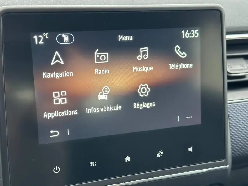 Écran tactile central du Renault Arkana 2025 affichant le menu principal avec options navigation, radio, musique et téléphone.