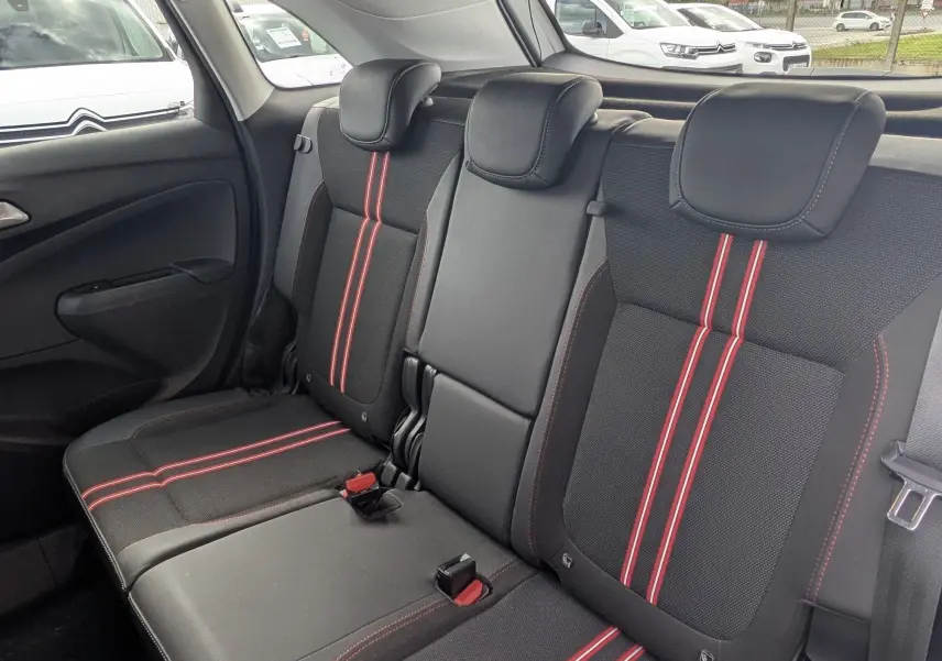 Vue intérieure arrière côté droit de la banquette noire avec surpiqûres et bandes rouges du Opel Crossland X GS Line.