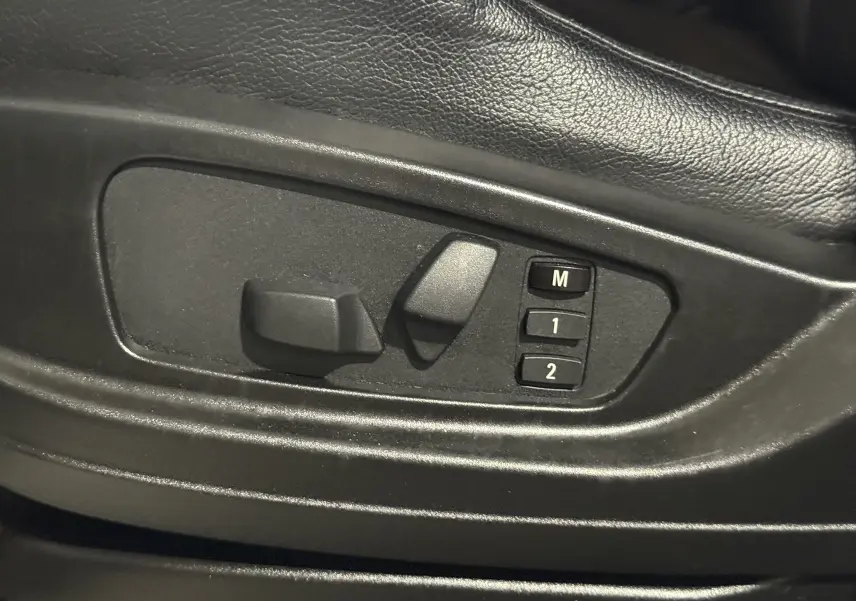 Réglages électriques des sièges avec mémoire sur le côté gauche d’un BMW X6 blanc xDrive 40d 2026 M Sport.