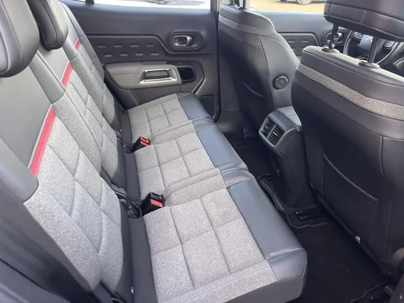 Vue intérieure des sièges arrière gris Stone Grey et noir cuir du Citroën C5 Aircross, avec appuie-têtes et aérateurs centraux.