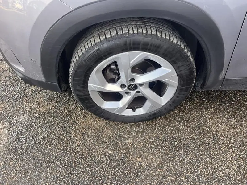 Gros plan sur la roue avant droite gris platinium d'une Citroën C5 Aircross avec jante alliage 18 pouces.