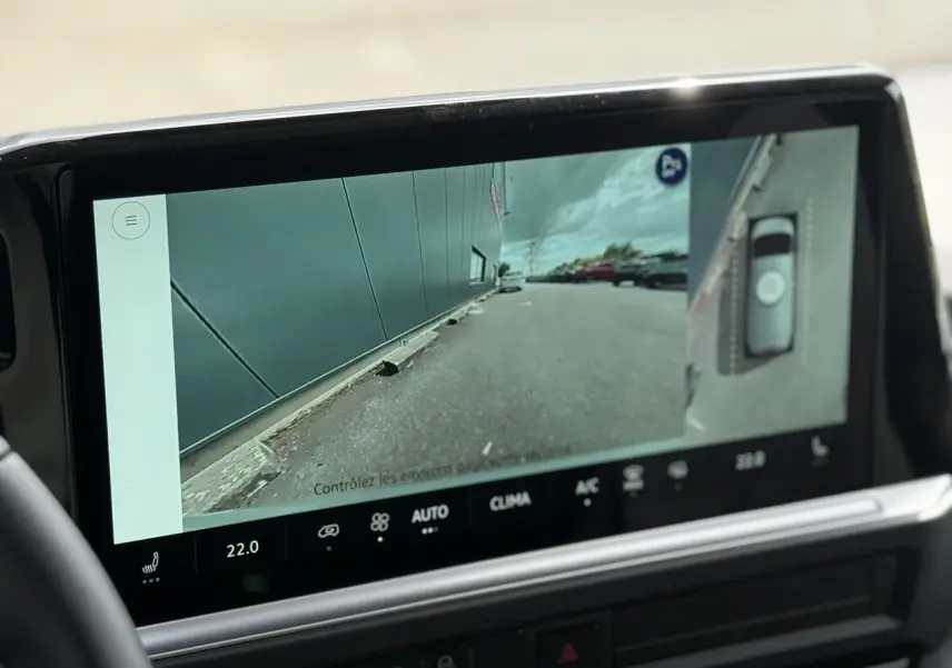 Écran tactile intérieur montrant la caméra de recul et vue latérale droite du Volkswagen Transporter gris argent 2026.