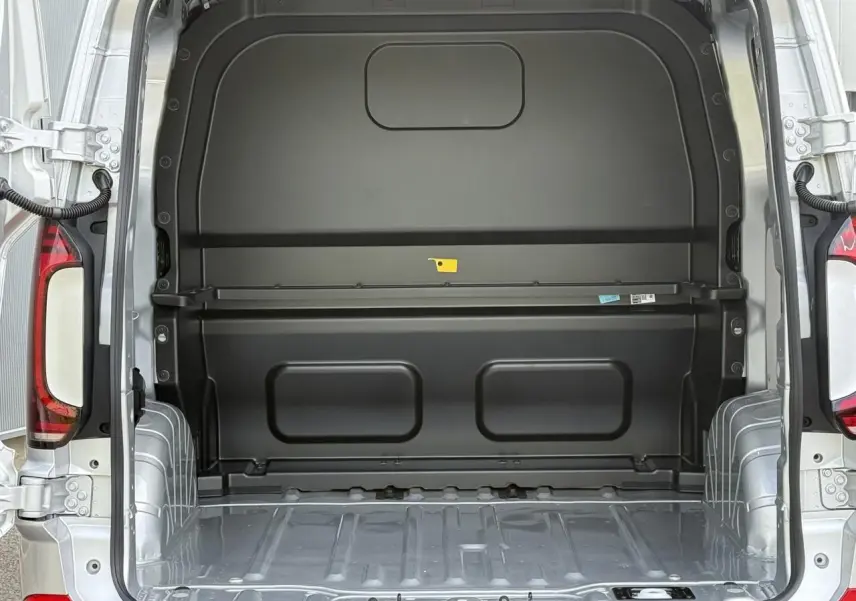 Vue arrière du Volkswagen Transporter T7 ProCab gris argent, montrant l'espace de chargement vide et la cloison noire.