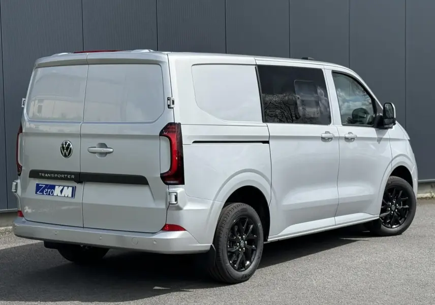 Vue 3/4 arrière droite d’un Volkswagen Transporter T7 ProCab gris argent avec jantes noires et feux arrière LED.