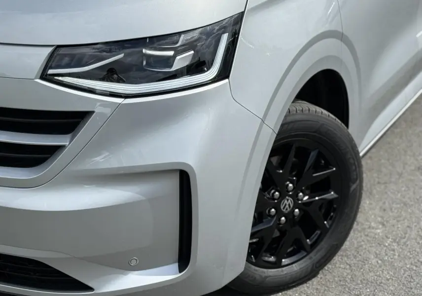 Gros plan sur l'avant droit gris argent du Volkswagen Transporter T7 avec jante alliage noir brillant et phare LED Matrix.