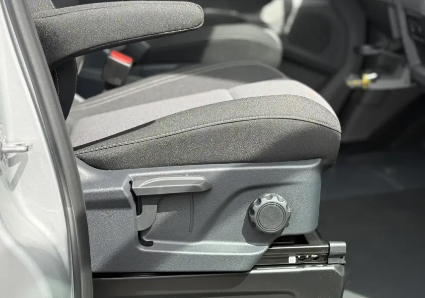 Détail du siège avant côté conducteur du Volkswagen Transporter T7 gris argent avec réglages manuels visibles.