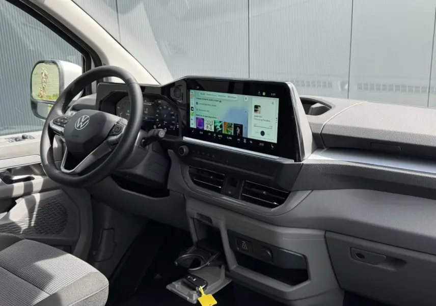 Vue intérieure côté conducteur du Volkswagen Transporter T7 ProCab 2026, tableau de bord moderne avec écran tactile 13 pouces.
