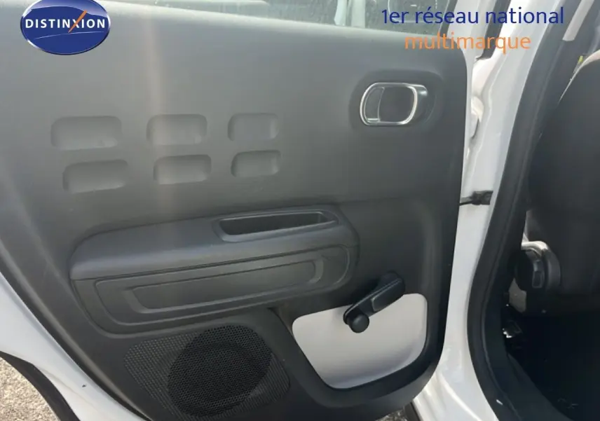 Vue intérieure côté gauche de la porte arrière blanche d'une Citroën C3 2018 avec poignée de fenêtre manuelle.