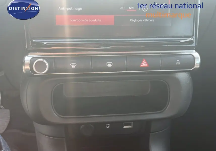 Vue rapprochée de la console centrale noire du Citroën C3 blanc, avec commandes de climatisation et écran tactile.