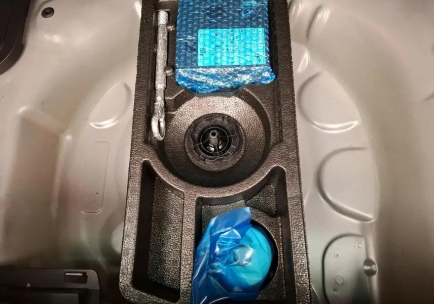 Vue plongeante sur le coffre d’un Citroën C3 Aircross 2023 gris foncé, montrant le rangement pour roue de secours.