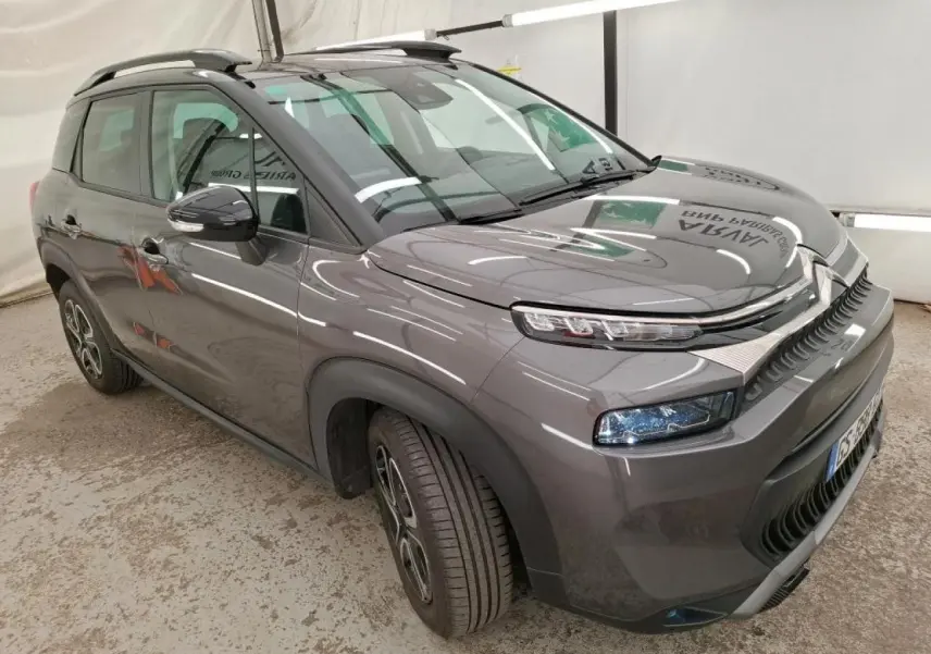 Citroën C3 Aircross gris foncé vue 3/4 avant droit, avec barres de toit noires et jantes 16 pouces design.
