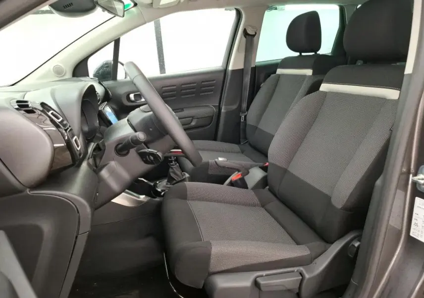 Intérieur avant du Citroën C3 Aircross gris foncé, vue côté conducteur avec sièges tissu Mica Grey et volant cuir.