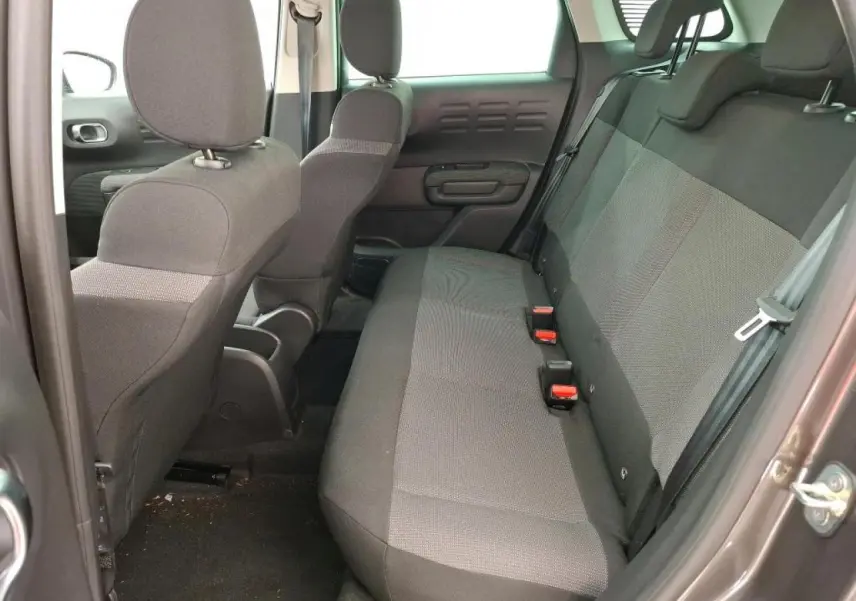 Vue intérieure côté arrière droit du Citroën C3 Aircross 2023 gris foncé, montrant la banquette arrière en tissu gris.