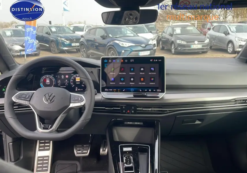 Vue intérieure avant de la Volkswagen Golf noire 2026 avec tableau de bord numérique et écran tactile central.
