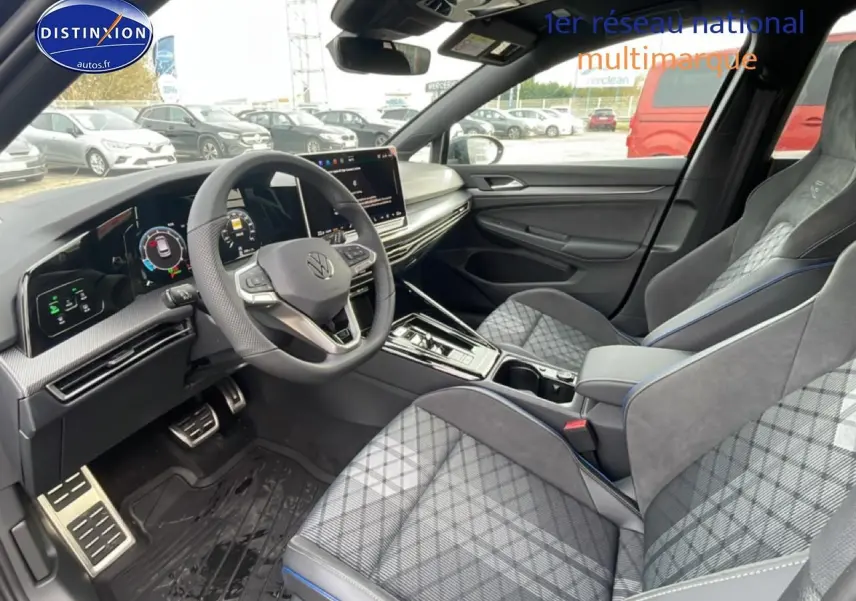 Vue intérieure côté conducteur de la Volkswagen Golf 2026 avec sièges sport gris à motifs et volant cuir multifonction.