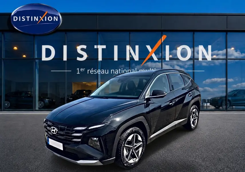 Hyundai Tucson 2026 noir en 3/4 avant droit, avec jantes alliage et calandre distinctive devant showroom Distinxion.