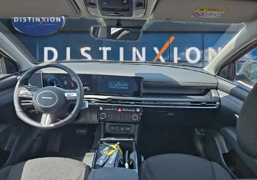 Vue intérieure avant du Hyundai Tucson 2026 noir, montrant tableau de bord moderne et volant multifonction cuir.