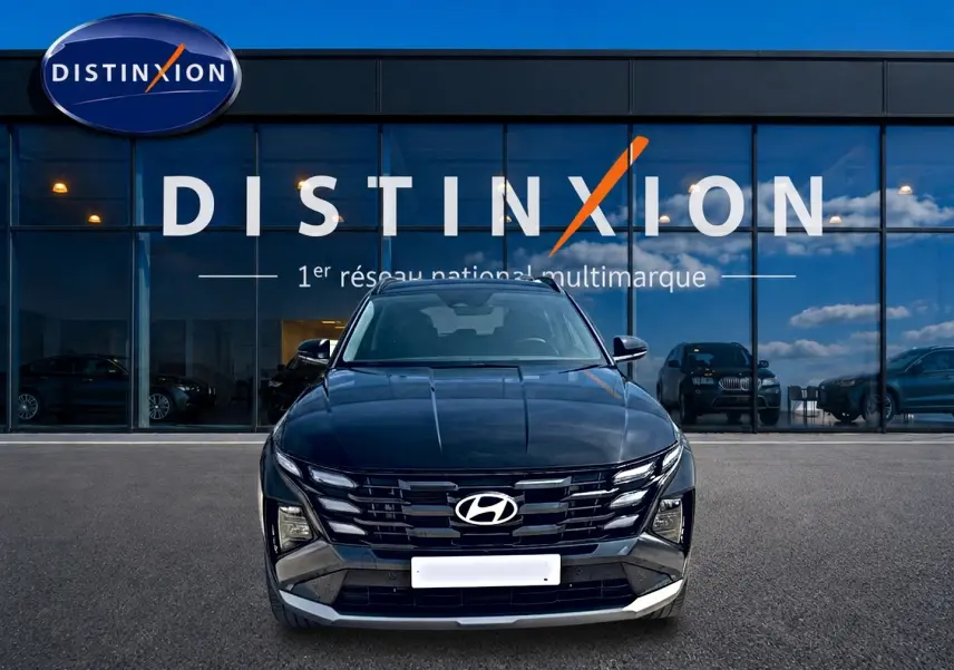 Vue frontale d'un Hyundai Tucson noir 2026 hybride essence, avec calandre distinctive et phares LED intégrés.